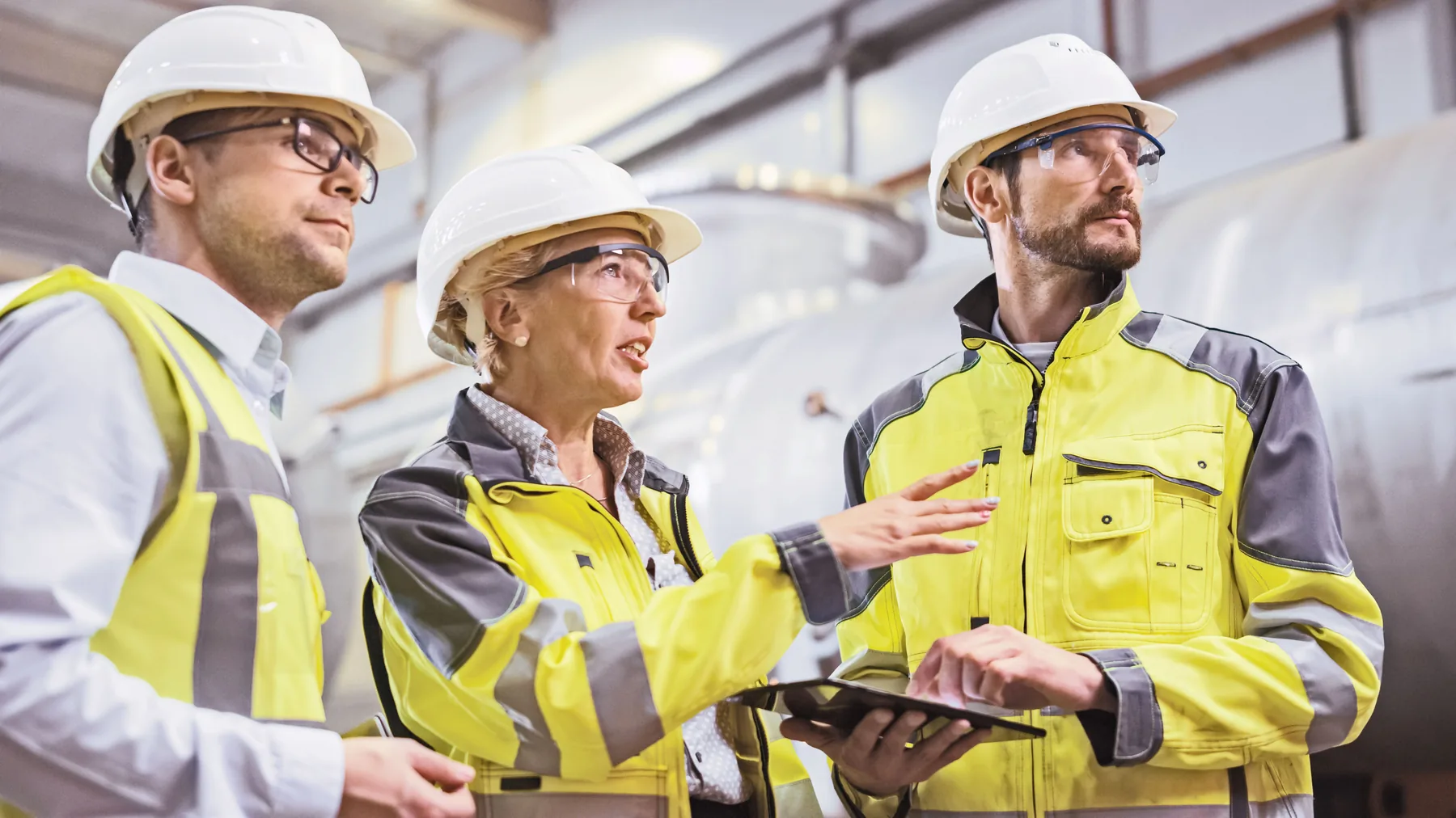 AMF MEP engineers on site in hard hats and hi-vis, reviewing a plant installation